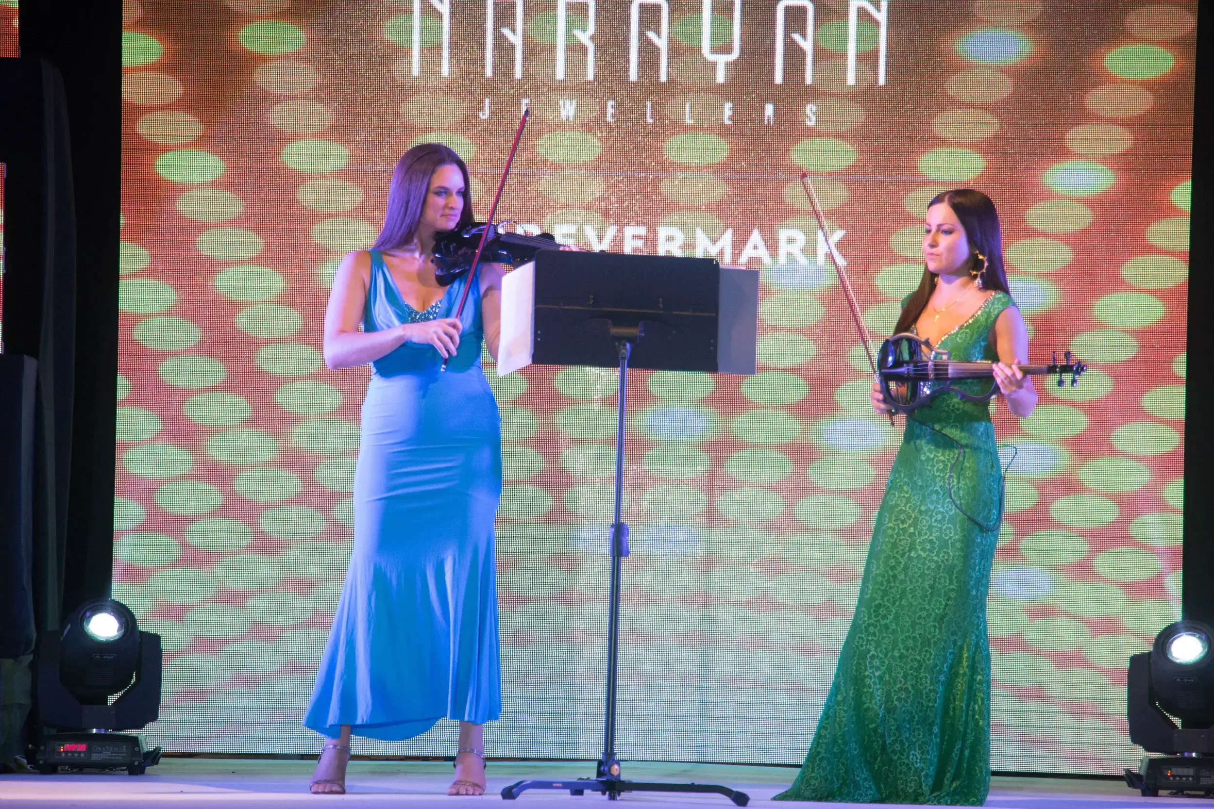 Group of men posing with large cartoon character inflatable figures at night outdoors